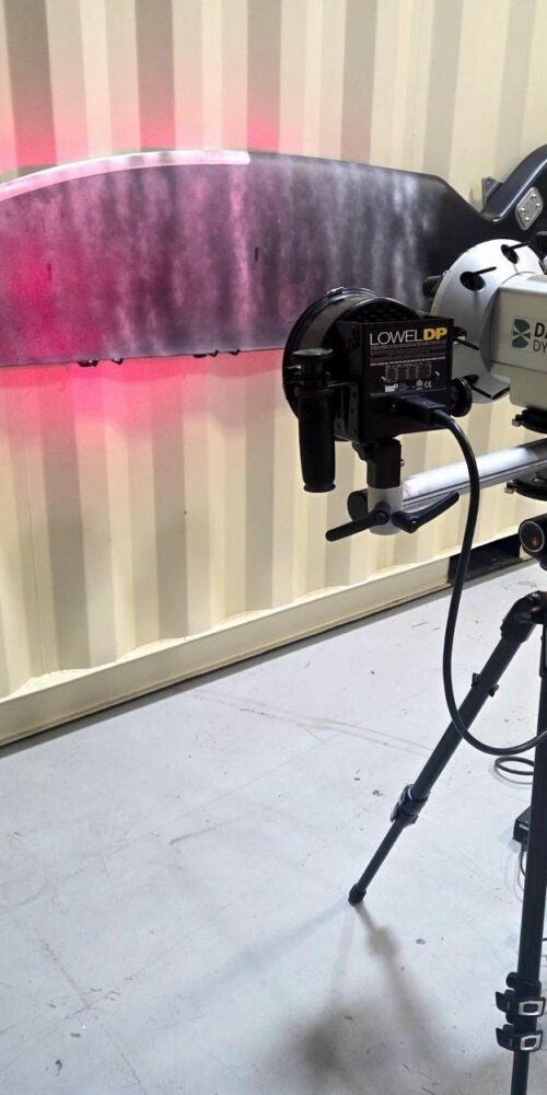 Laser shearography NDT inspection system scanning a composite panel with red laser illumination