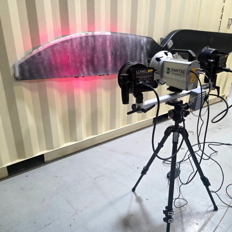 Laser shearography NDT inspection system scanning a composite panel with red laser illumination