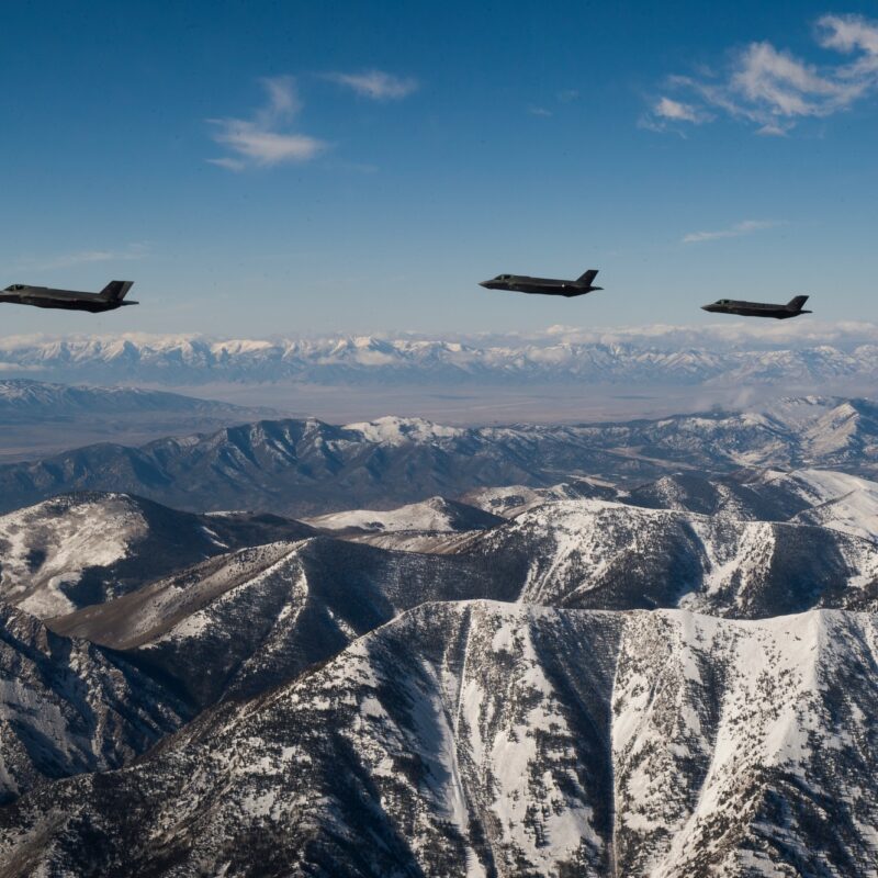 Three F-35A Lightning II fighters from Hill Air Force Base flying over snow-covered Utah mountains, illustrating CUI protection for F-35 program data